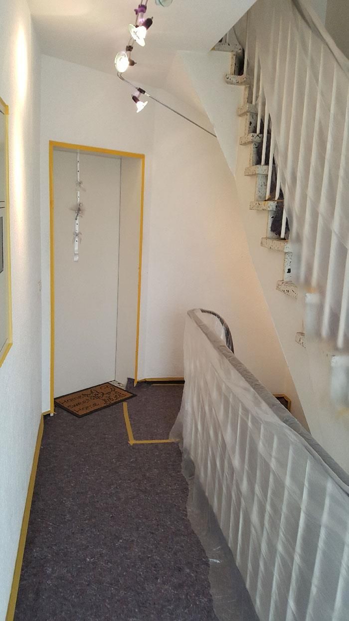 Ein Flur mit einer Treppe, die in den zweiten Stock eines Hauses führt.