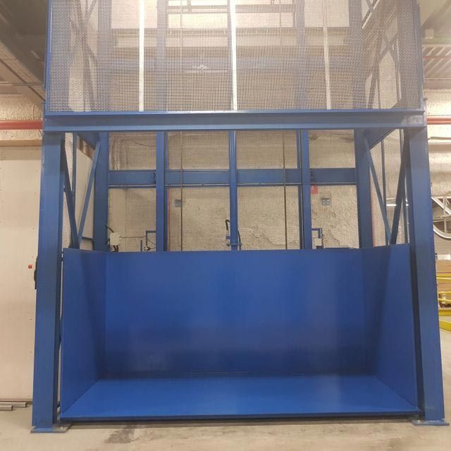 Un ascensor azul está estacionado en un almacén.