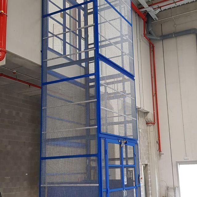 Un ascensor azul y transparente en un edificio.