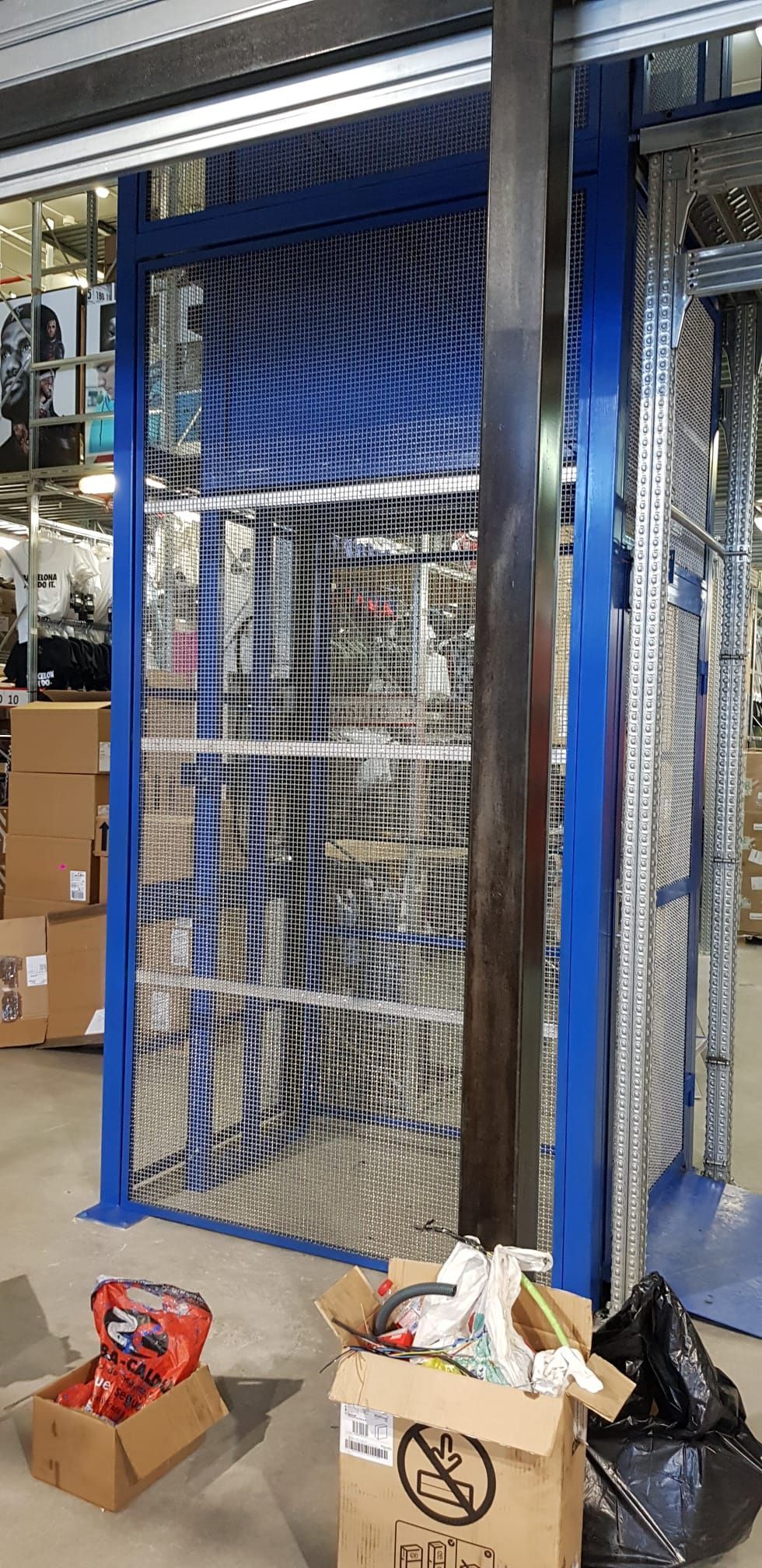 Un almacén con una valla y cajas en el suelo.