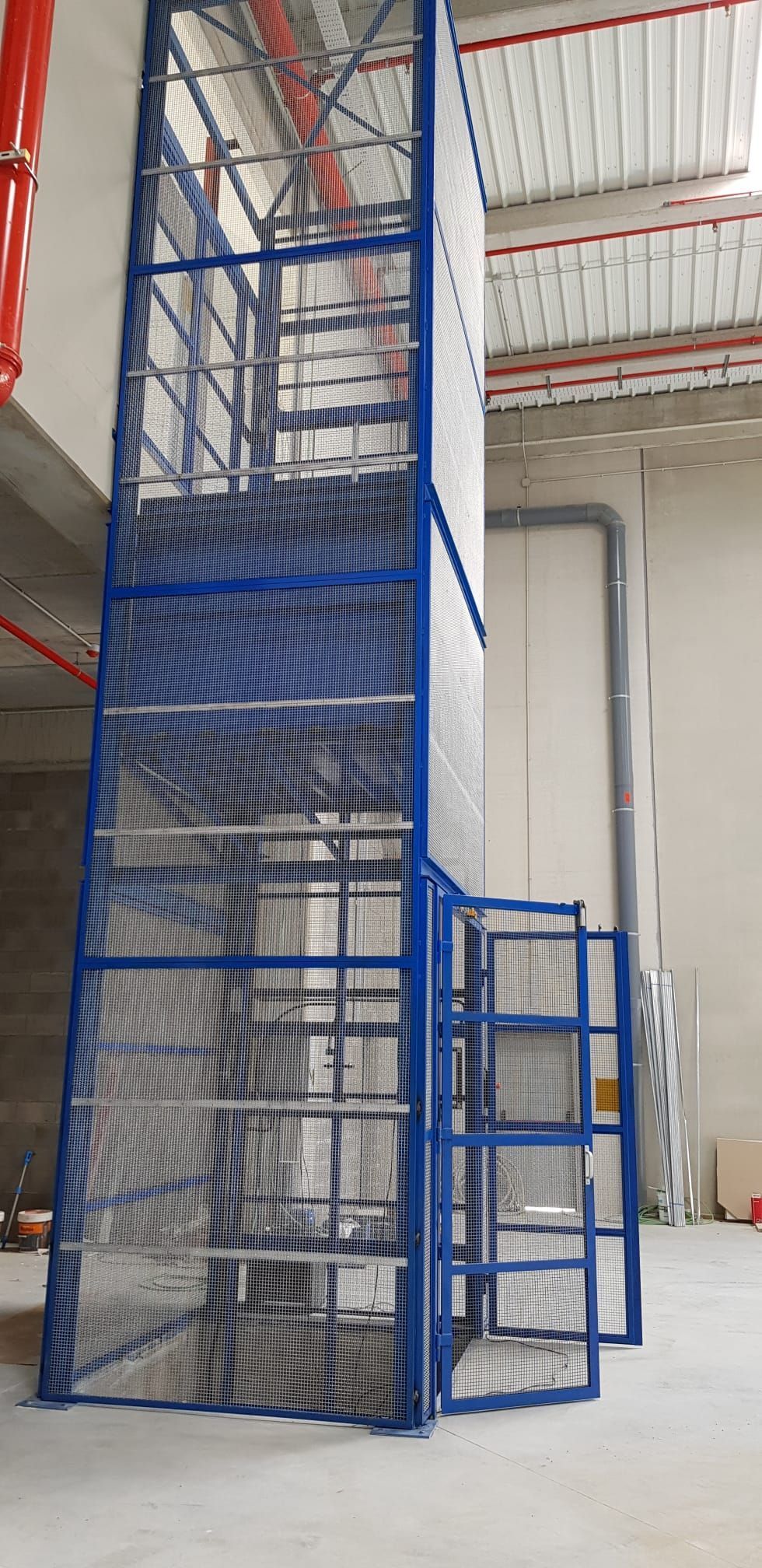 Una escalera azul en un edificio con una valla alrededor.