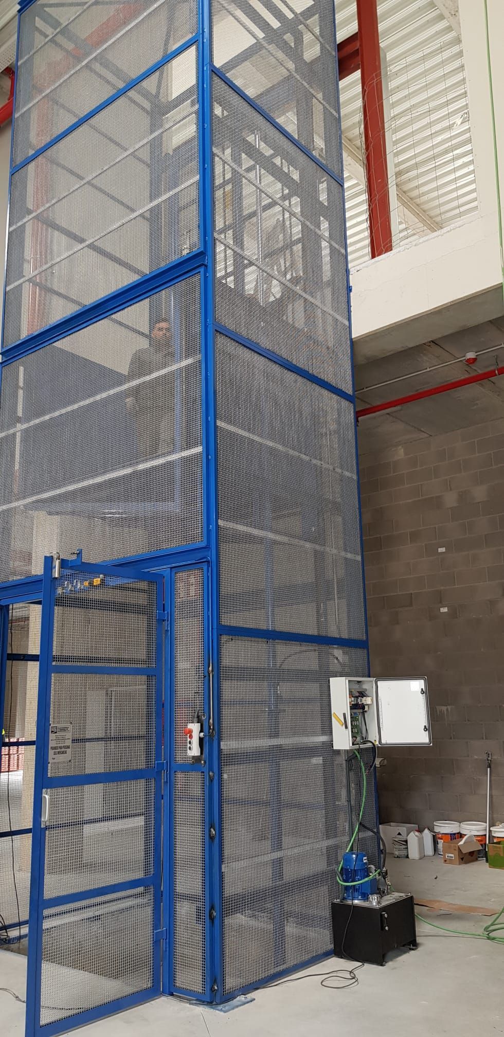 Una valla azul rodea un ascensor en un edificio.