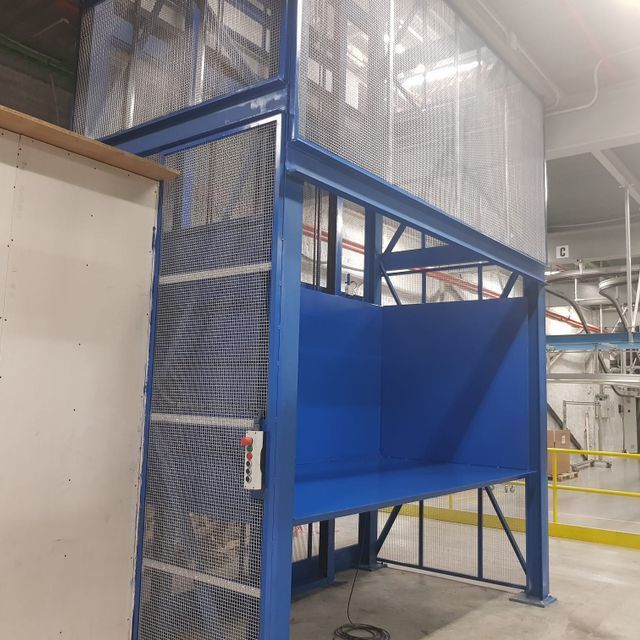 Una escalera azul en un edificio con una valla alrededor.
