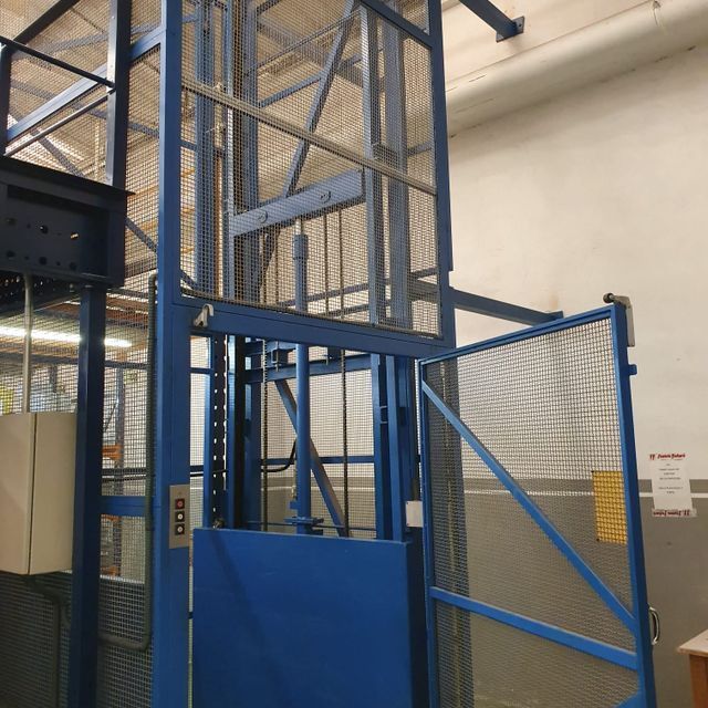 Un ascensor azul con la puerta abierta y un cartel que dice no entrar