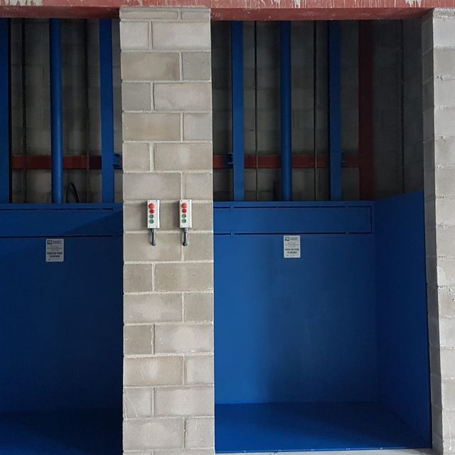 Una pared de ladrillos con una puerta azul y un cartel que dice 