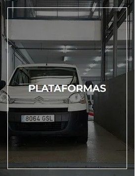 Una furgoneta blanca está aparcada en un garaje debajo de un edificio.