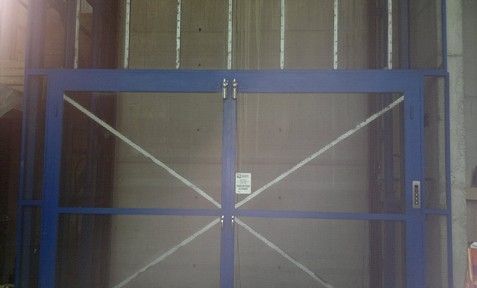 Una puerta azul está delante de un muro de hormigón.