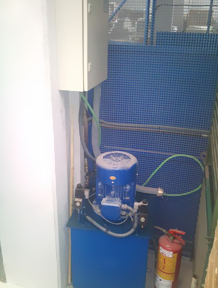 Un extintor de incendios se encuentra al lado de una máquina azul.