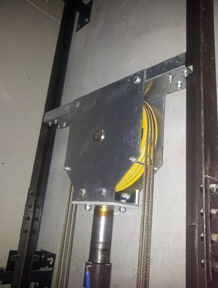 Una polea amarilla está unida a un marco de metal.