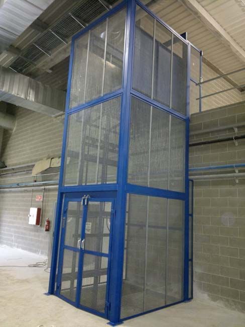 Un ascensor azul con una valla alrededor en un edificio.