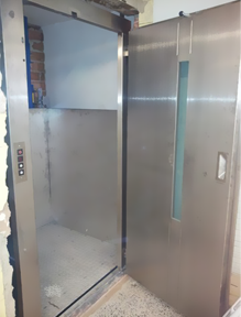 Un ascensor de acero inoxidable con la puerta abierta.