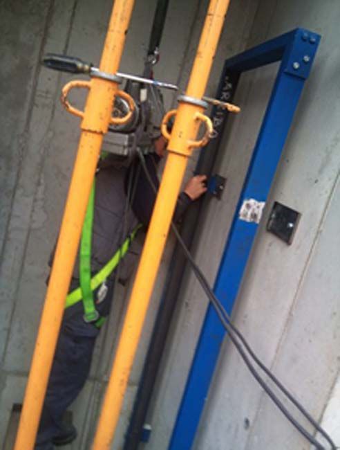 Un hombre que lleva un arnés de seguridad está trabajando en una tubería.