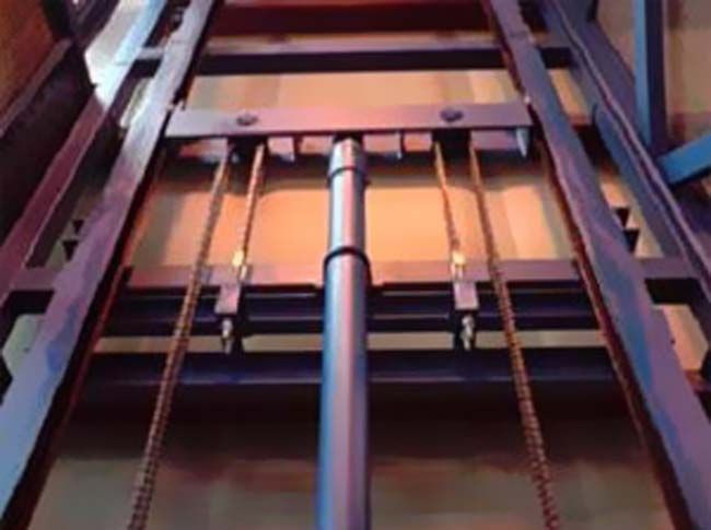 Un primer plano de una estructura metálica con cadenas que suben y bajan.