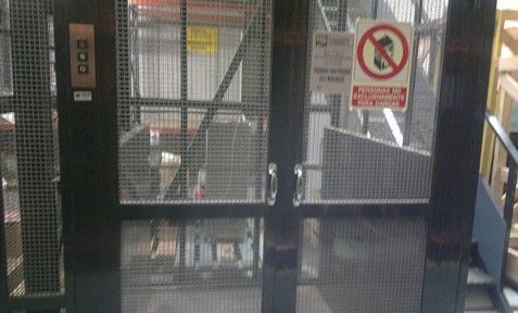 Un ascensor con un cartel de no perros en la puerta.