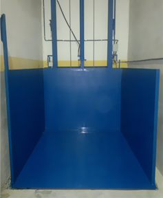 Un contenedor azul está en una habitación con una pared blanca.