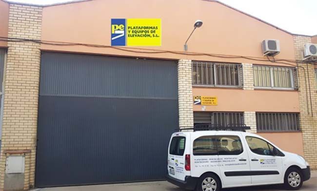 Una camioneta blanca está estacionada frente a un edificio que dice ps