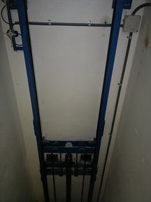 El interior de un ascensor con un marco azul y una pared blanca.