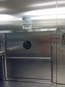 Un ascensor de acero inoxidable con puerta y botones.