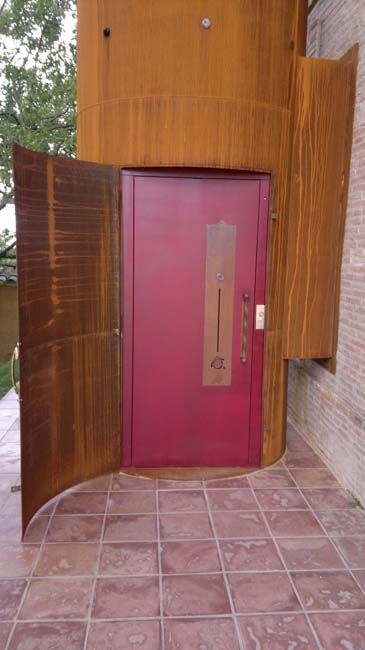Una puerta roja está abierta en un suelo de baldosas.