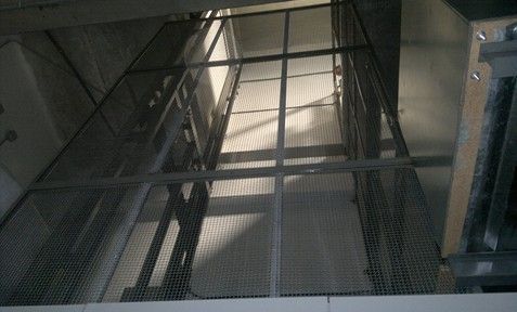 Mirando hacia un ascensor de metal con una valla a su alrededor