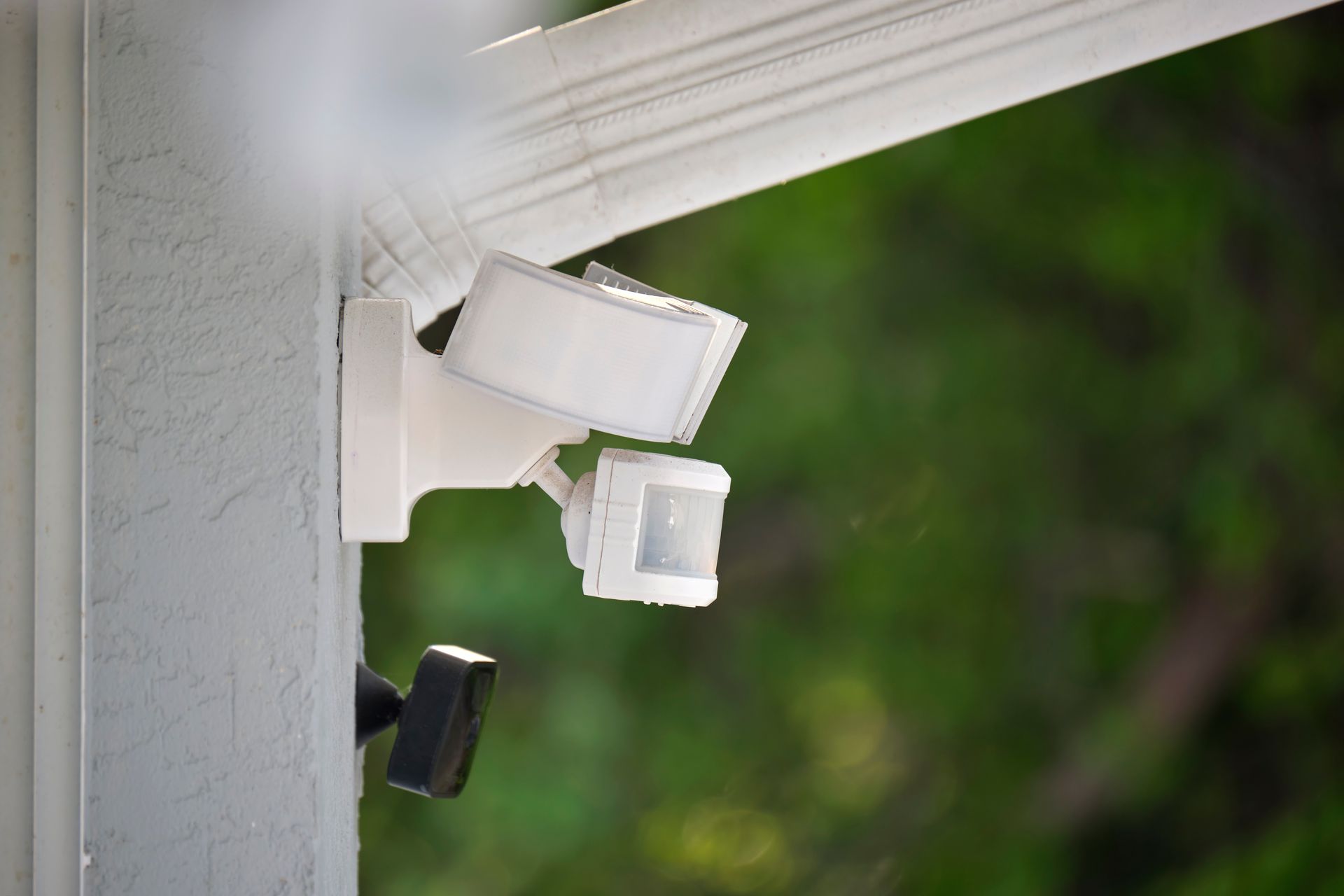 Caméras de sécurité blanches fixées à un coin de maison, pointées vers l'extérieur sur fond vert