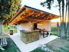 Una estructura de madera con una mesa y sillas bajo un techo.
