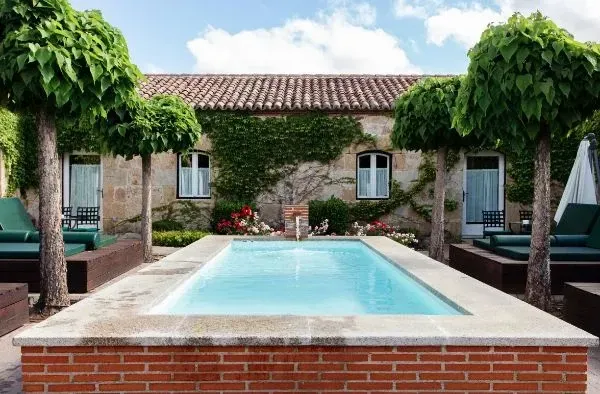 Una gran piscina frente a un edificio de ladrillo.