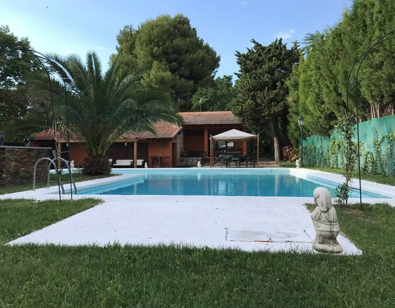 Una gran piscina con una estatua en primer plano