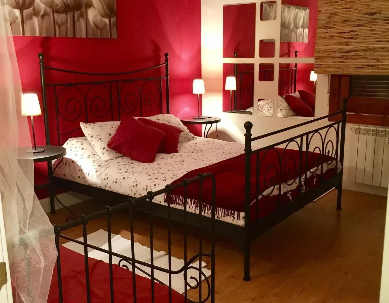 Un dormitorio con paredes rojas y una cama negra.