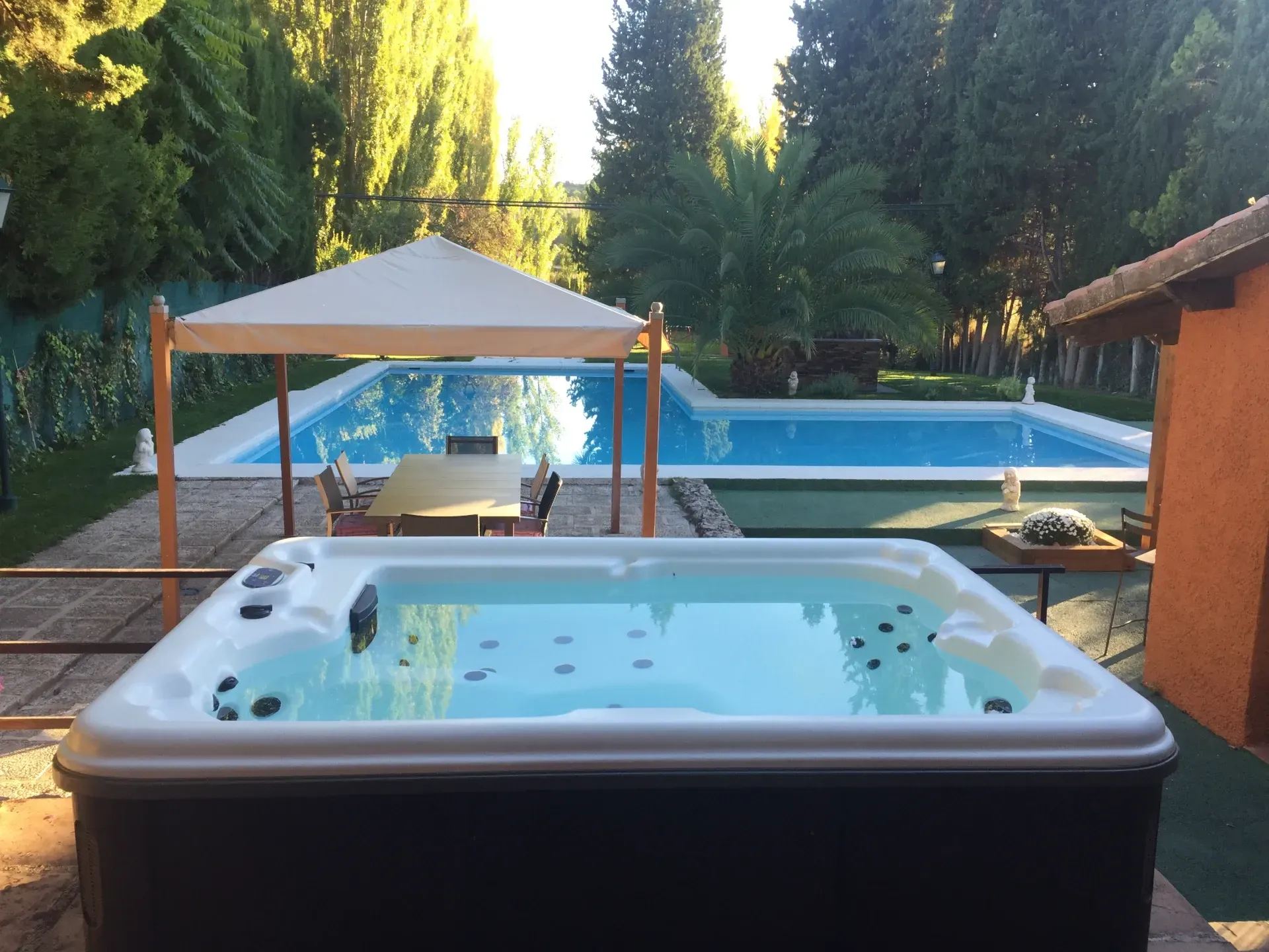 Un jacuzzi frente a una gran piscina