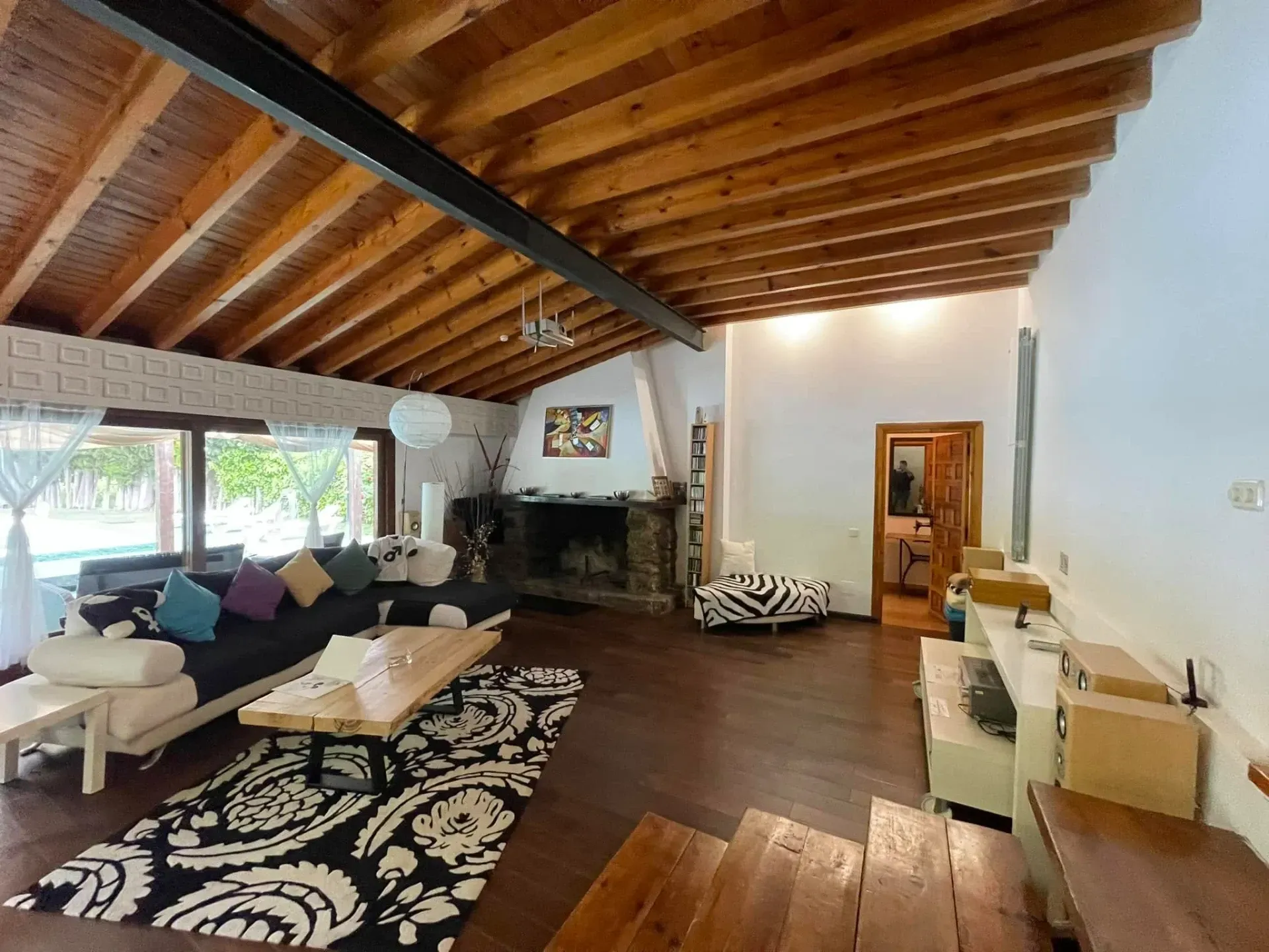 Una sala de estar con techo de madera y chimenea.