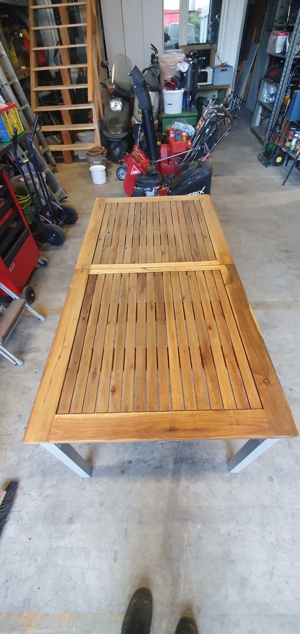 Eine Schubkarre voller Pflanzen und ein Rechen in einem Garten