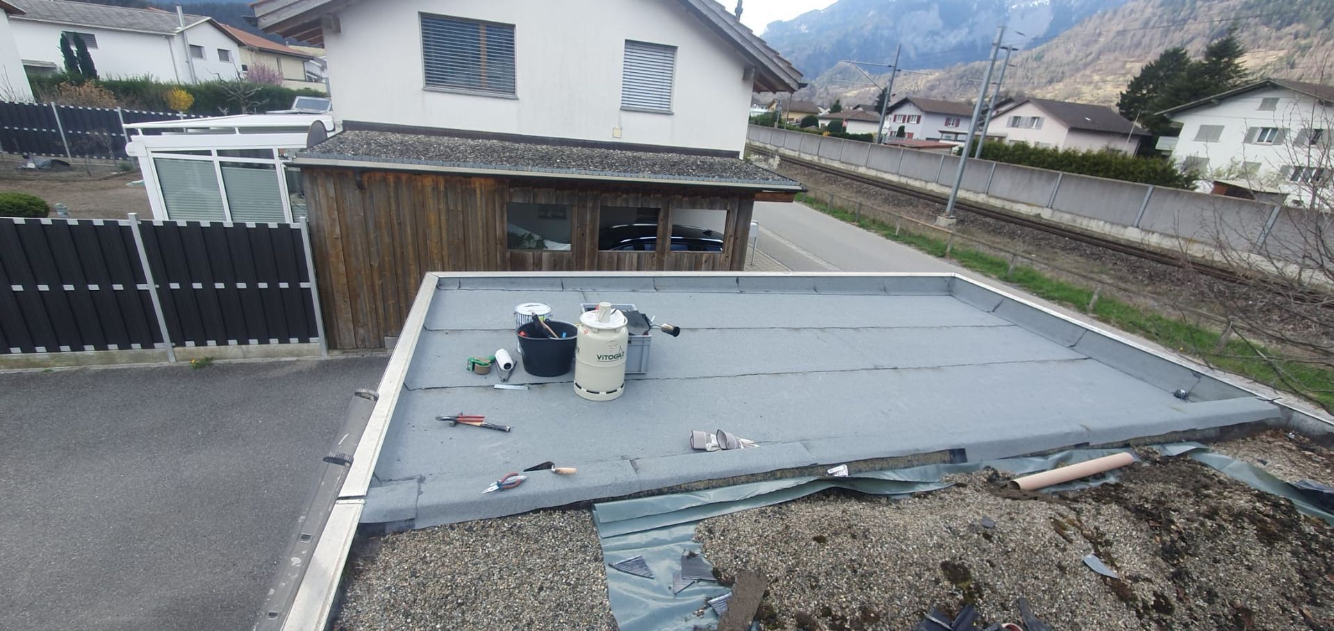 Eine rote Schneefräse räumt Schnee vom Gehweg.