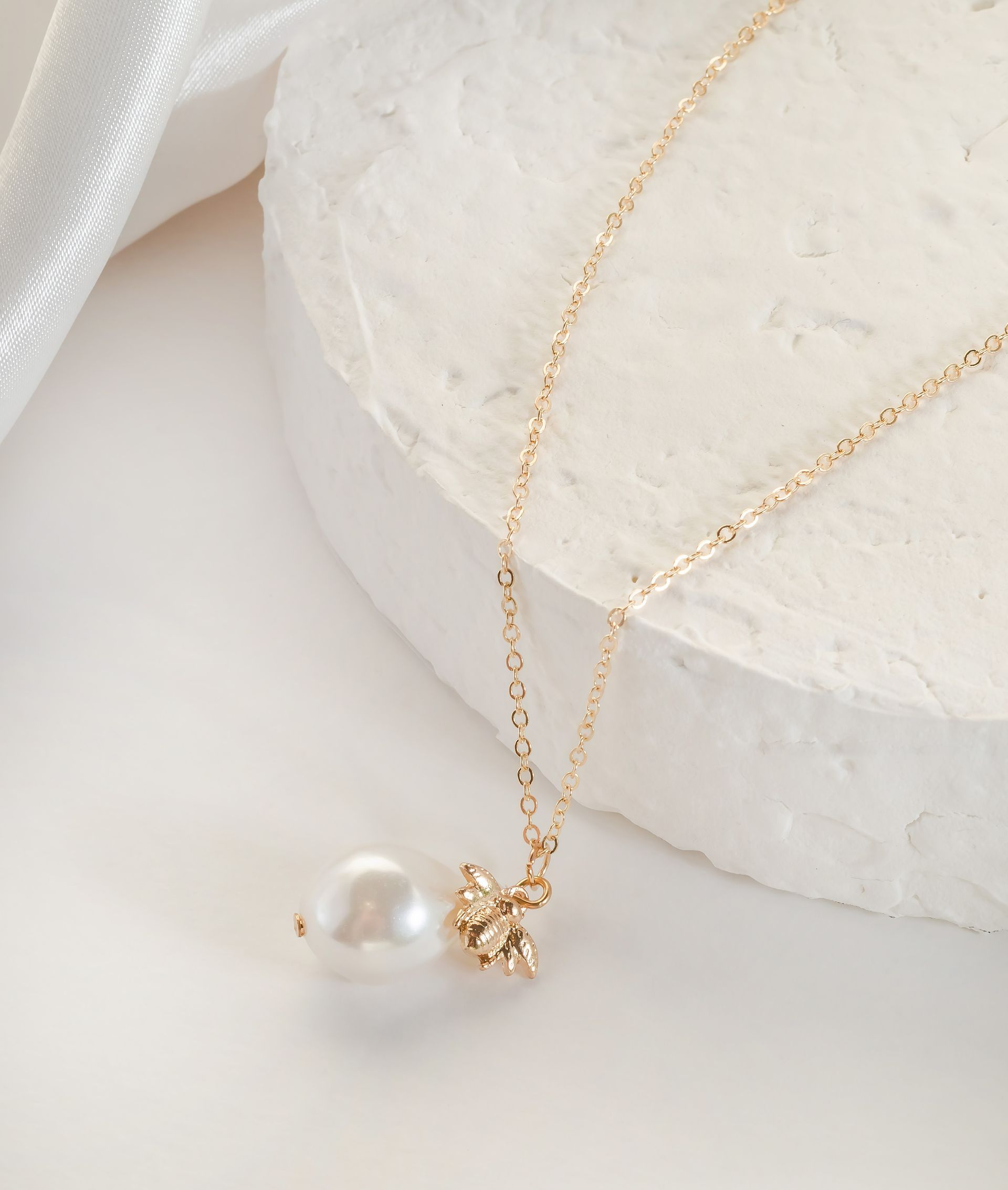 Un collier en plaqué or avec une pierre nacrée