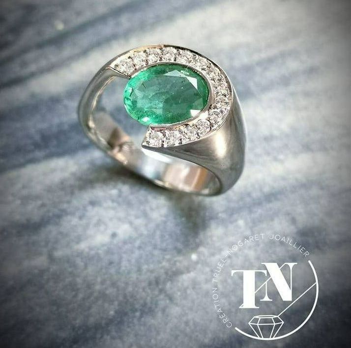 Une bague en or blanc avec des diamants et une émeraude