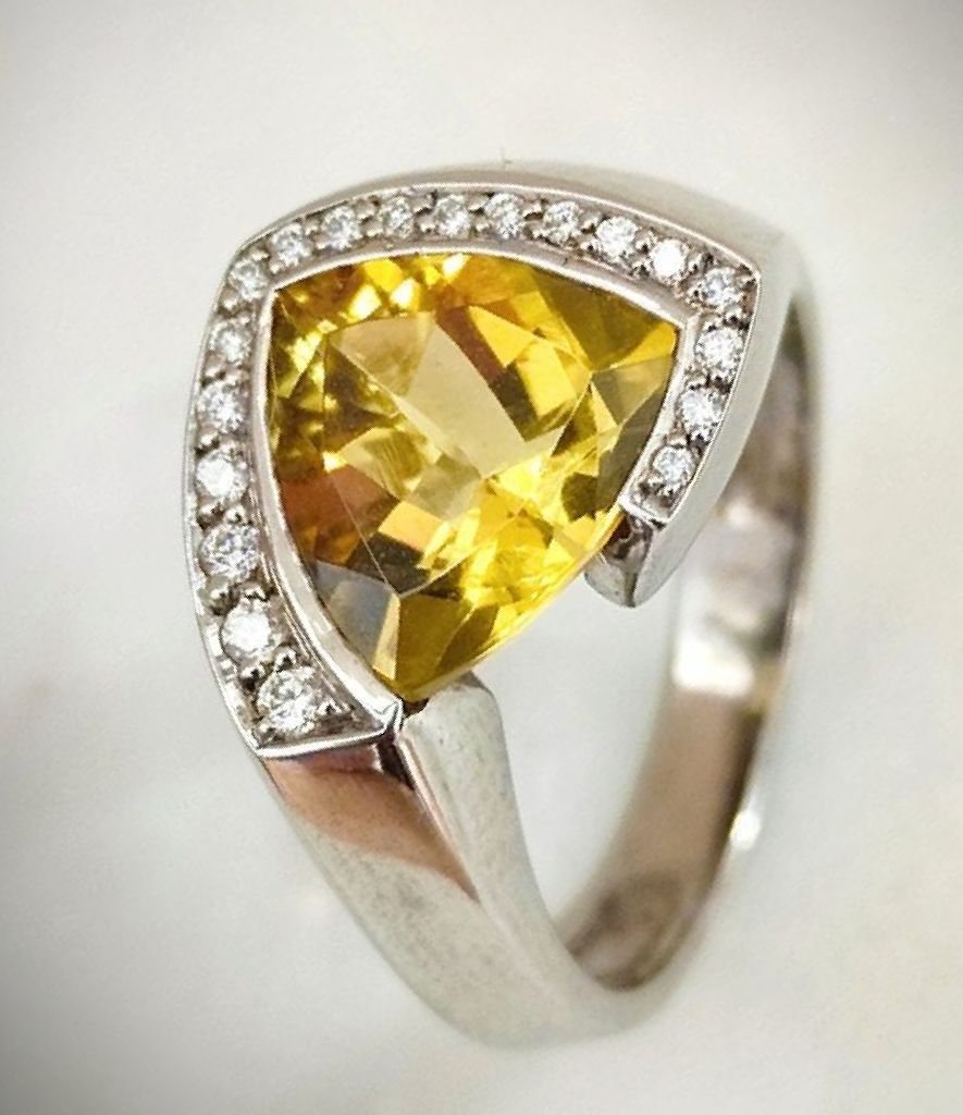 Une bague en or blanc avec des éclats de diamants et un saphir jaune