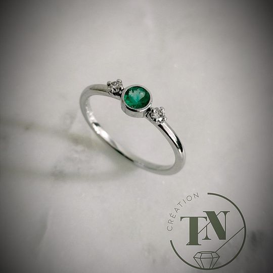 Une bague en or blanc avec une émeraude