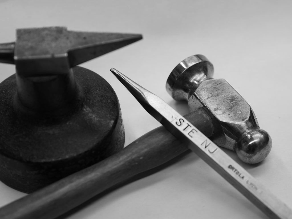 Une enclume miniature, un marteau et un burin de bijoutier