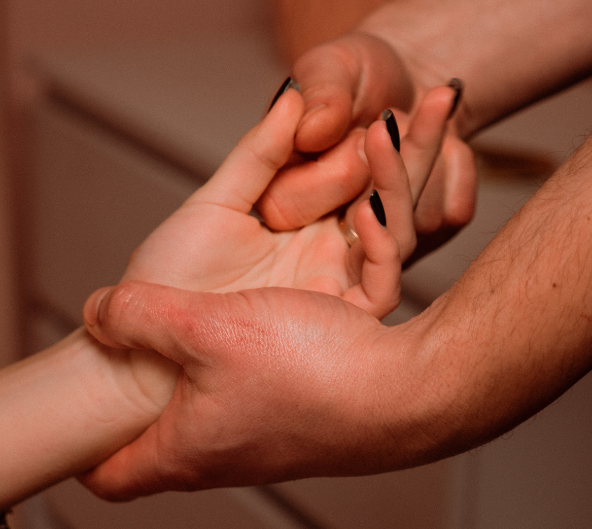 Deux mains se tenant. L'une d'elles porte du vernis à ongles noir.