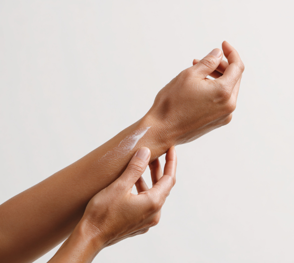 Personne appliquant une lotion sur son poignet.