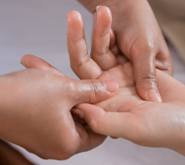 Mains recevant un massage, paumes vers le haut, avec de l'huile appliquée.