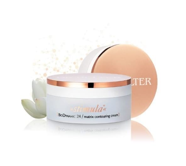 Pot blanc de crème contouring matrice BioDynamic 24 avec bord et couvercle dorés, fleur blanche, sur fond clair.