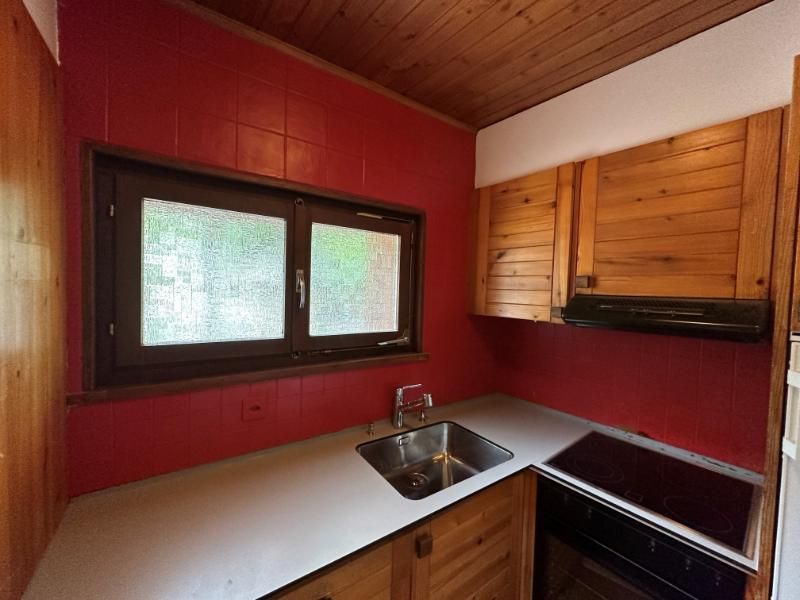 Une cuisine avec des armoires en bois et un évier avant rénovation.