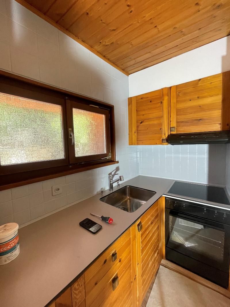 Une cuisine avec armoires en bois, un évier et une cuisinière.