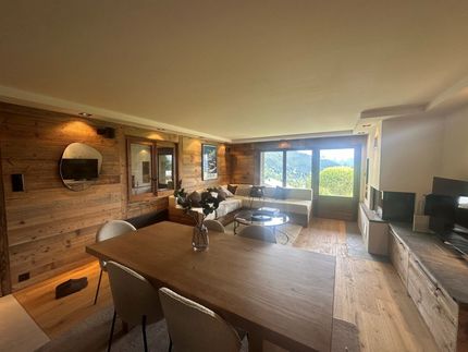 Un salon avec une table et des chaises en bois et un canapé.