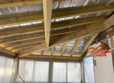 Une pièce avec un plafond en bois et beaucoup de fenêtres.