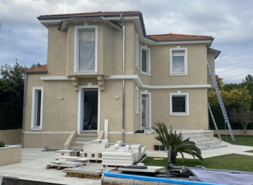 Une grande maison avec une piscine devant