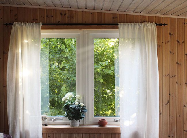 Fenêtre en PVC avec des rideaux blancs de chaque côté