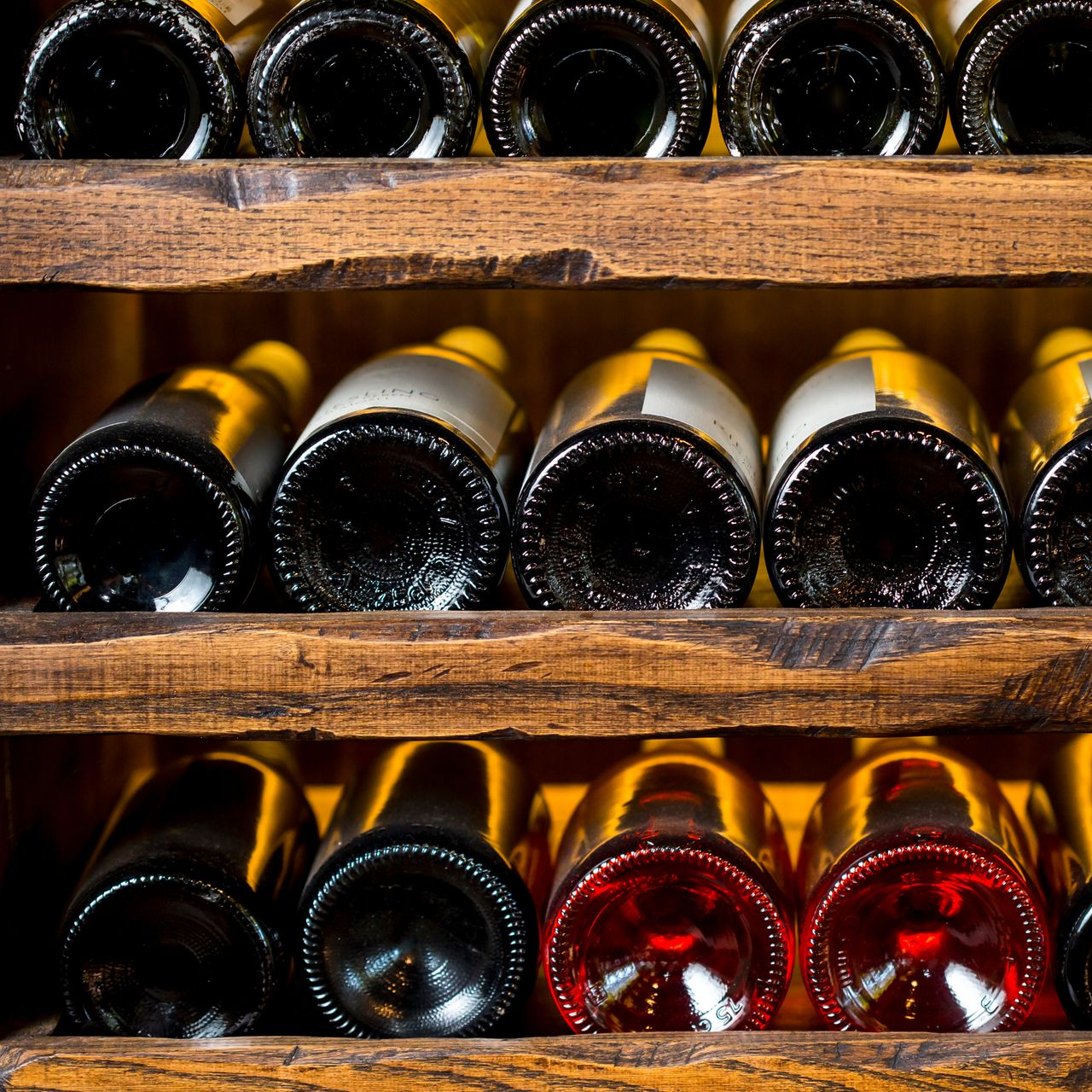 Bouteilles de vin rangées horizontalement dans des casiers en bois.