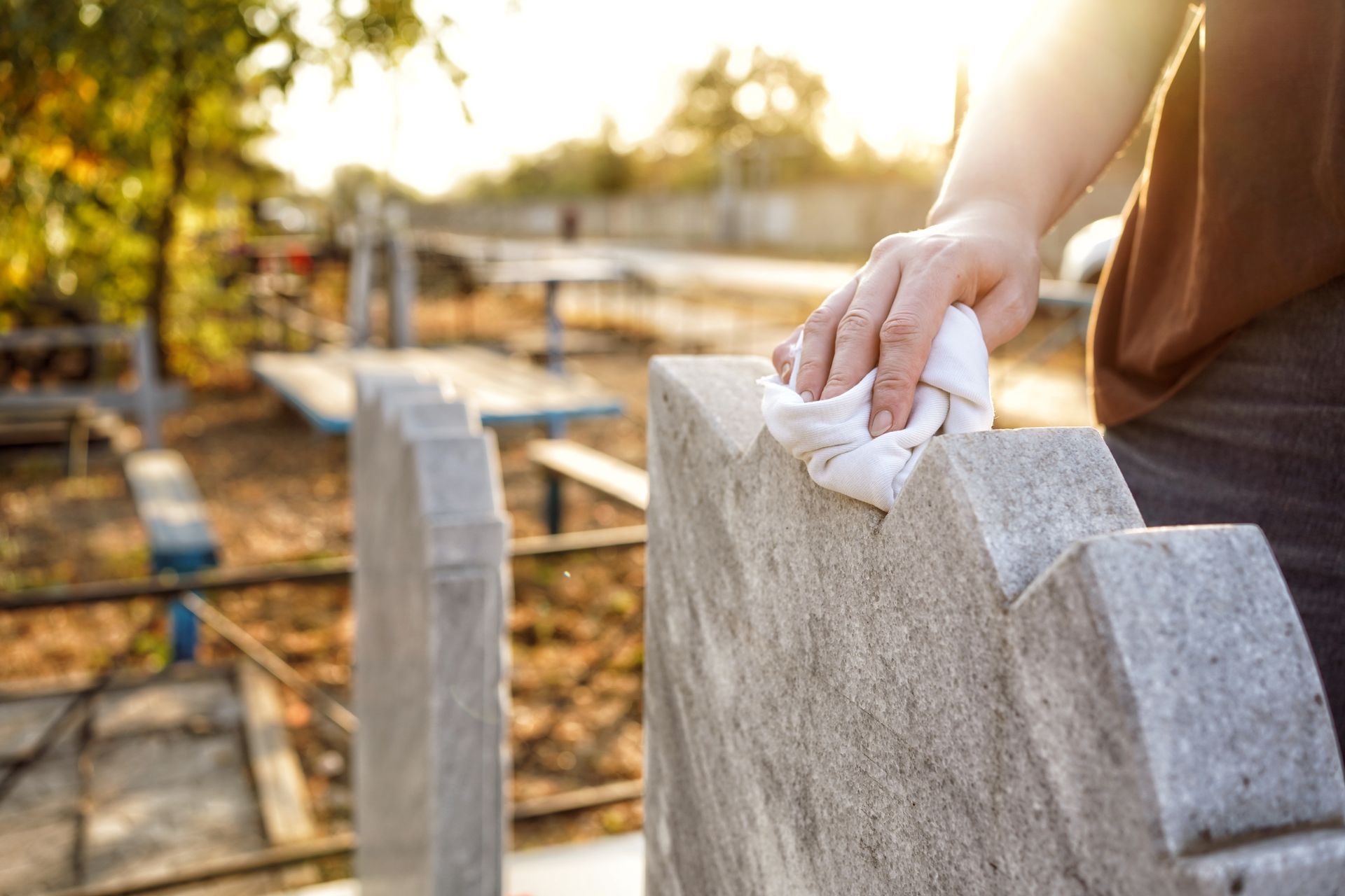 Une personne nettoie les sépultures d'un cimetière